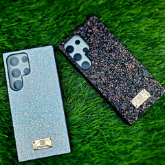 Two smartphones with glittery finishes on a grass background