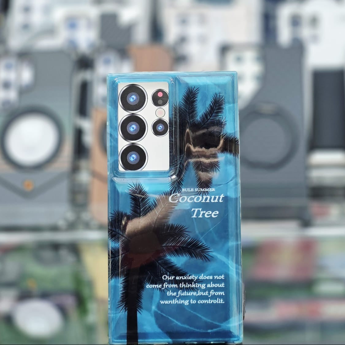 Phone case with coconut tree design on a blurred background