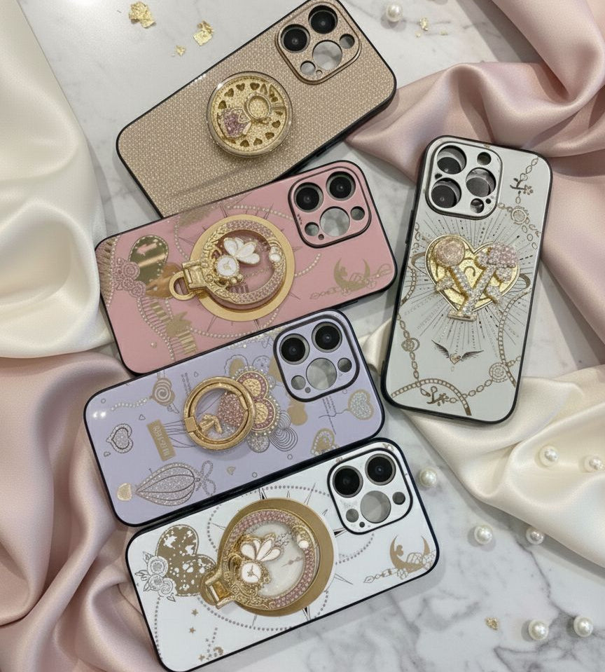 Five phone cases with decorative designs on a soft fabric background