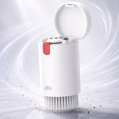 A white cylindrical cleaning brush with an open lid, shown on a light marble-like surface with a soft white and gray background and swirling light effects. The brush has a small red tab and the brand name JBQ printed on the front.