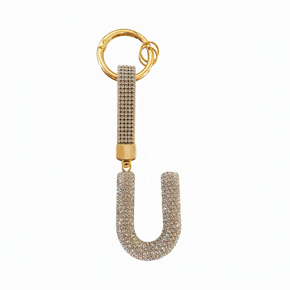 A gold-plated letter U keychain embellished with pave-set clear rhinestones, featuring a matching rhinestone-encrusted strap and split key ring, shown on a plain white background.
