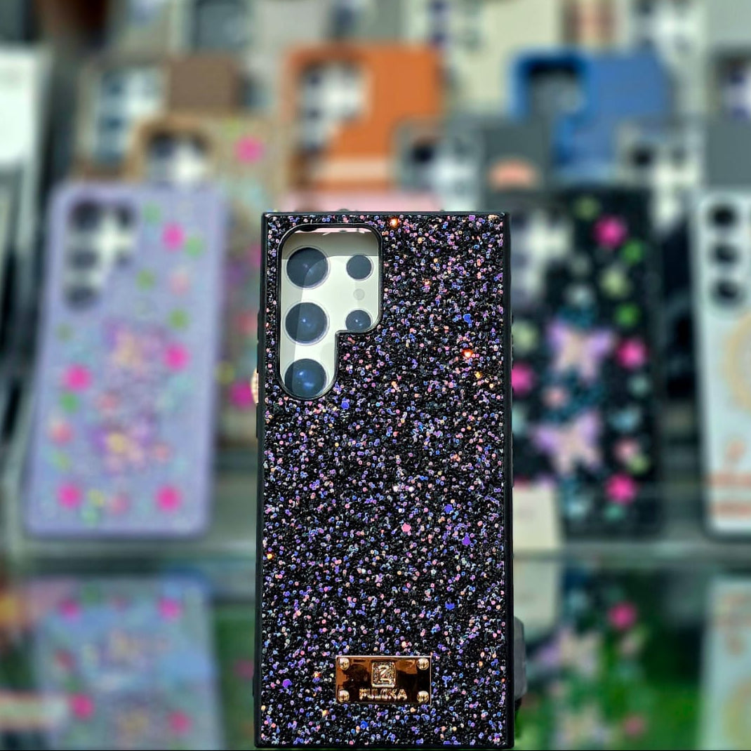 Glittery phone case with brand logo on a blurred background of other phone cases.