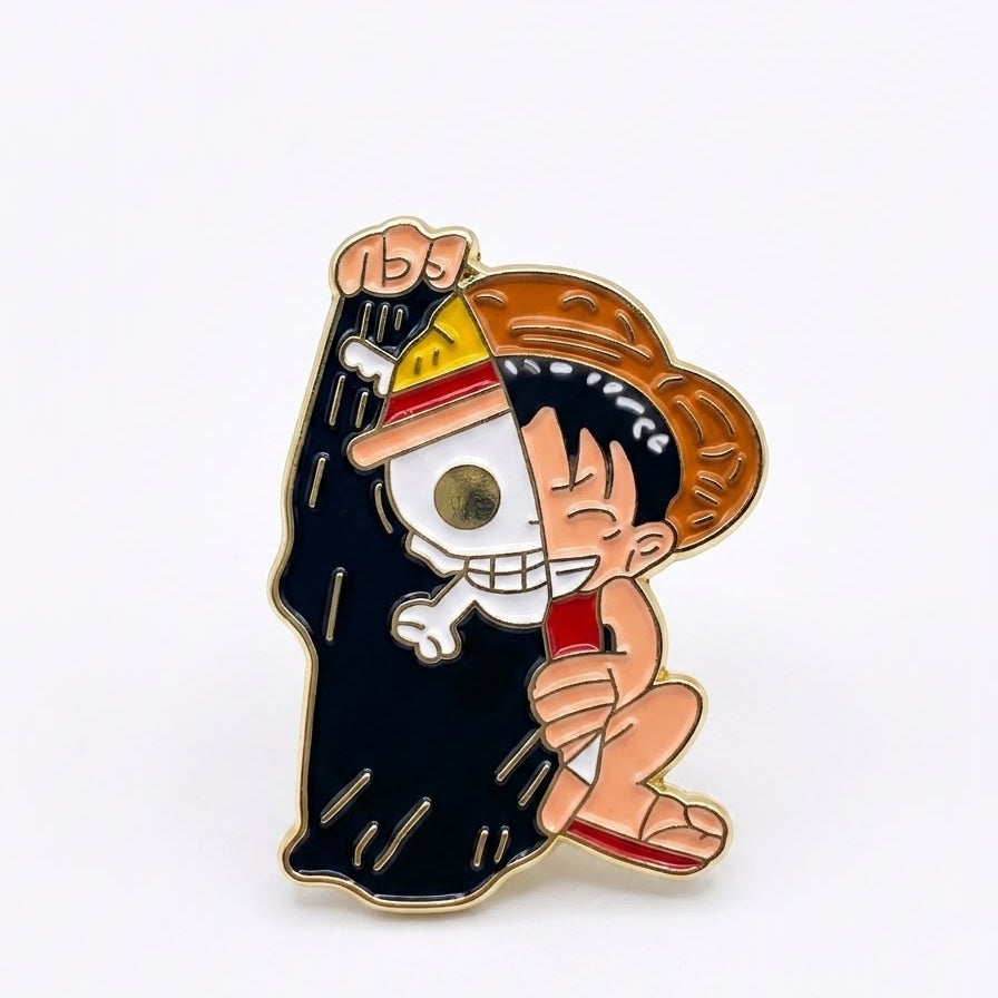 A cartoon enamel pin featuring a character in a black robe holding a skull wearing a straw hat, with a small red heart, on a plain white background.